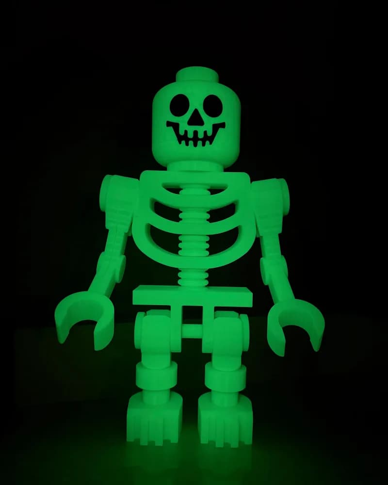 A glow-in-the-dark green 3D-printed skeleton figure, about 16 inches tall