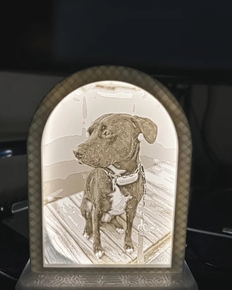 A lit 3D-printed arch lamp showing a photo of a dog