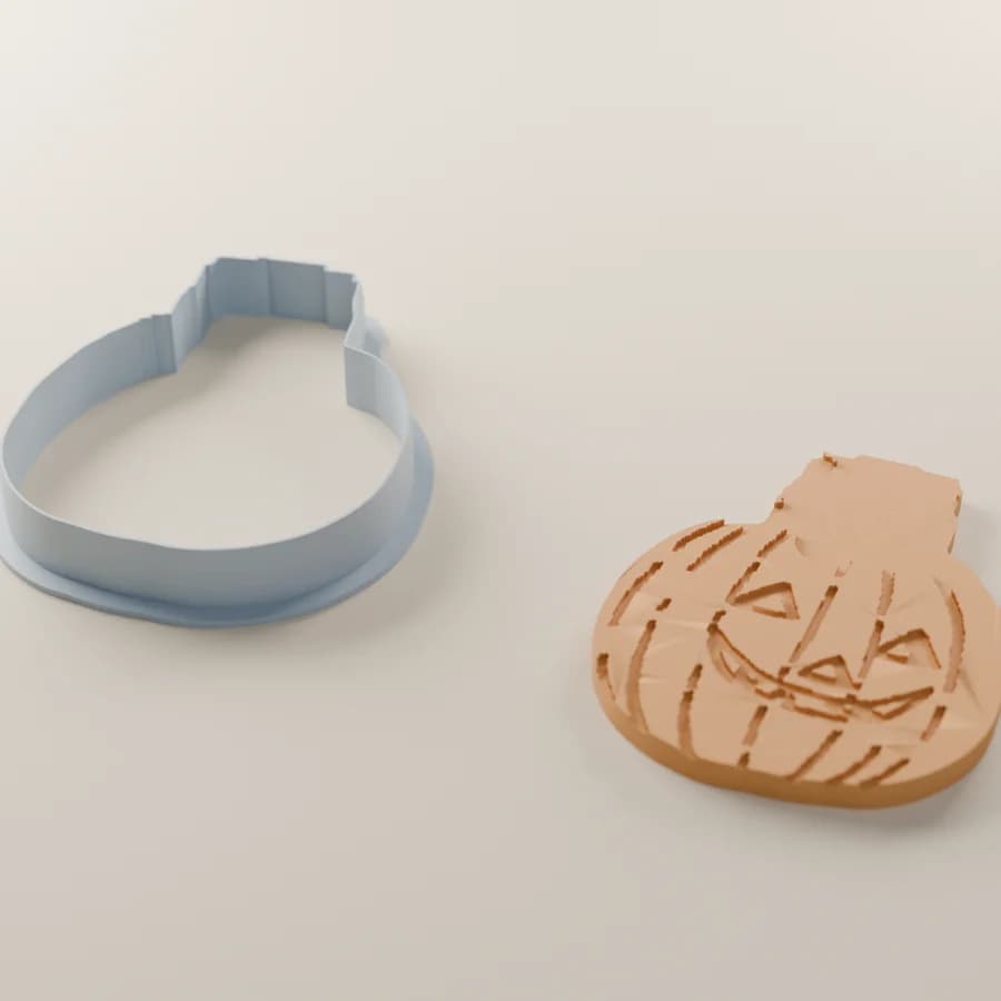A render of the kitten-and-pumpkin cutter beside the cookie it cuts