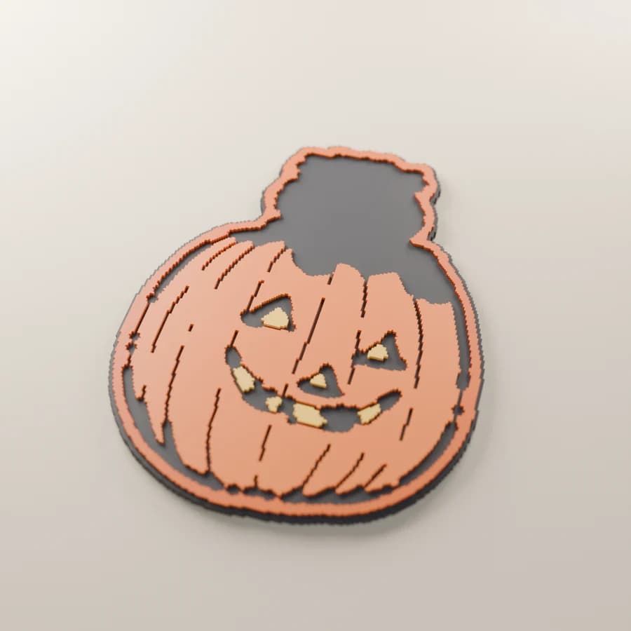 A render of the engraved kitten-and-pumpkin piece, painted orange with yellow eyes and teeth