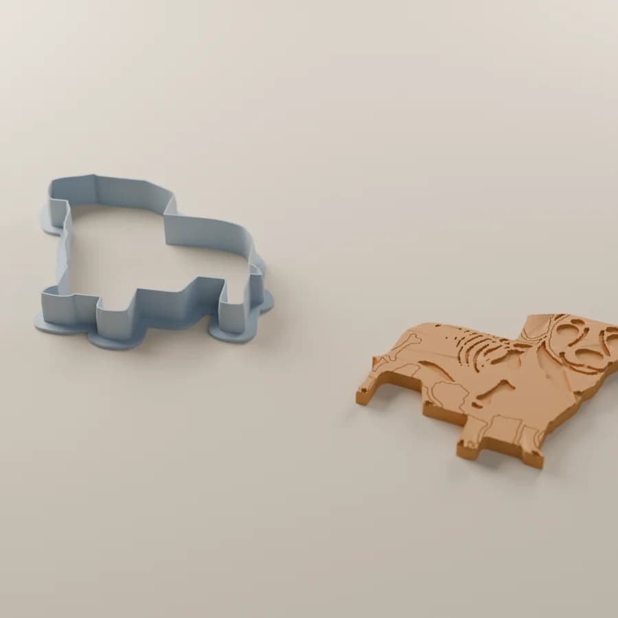 A render of the dog cutter beside the cookie it cuts, skeleton lines pressed in