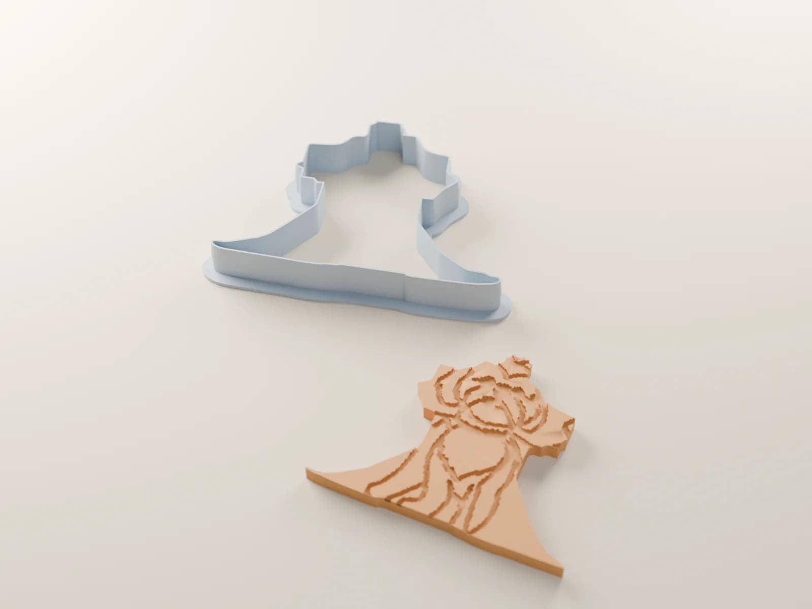 A render of the caped dog’s cutter beside the cookie it cuts